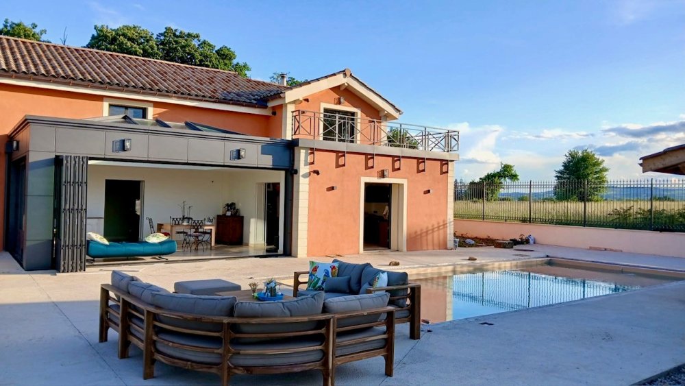 ? Rénovation et extension d’une habitation d’exception près de Villefranche-sur-Saône (69), intégrant des baies accordéon, une toiture vitrée et des stores sur-mesure.