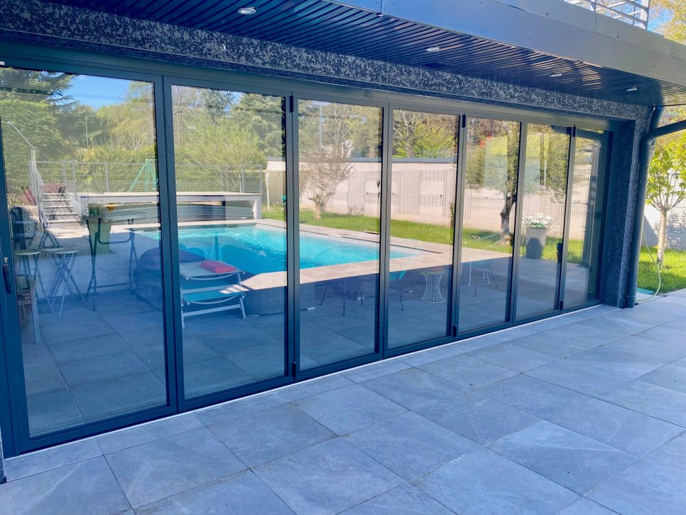 Fermeture sur-mesure de terrasse en baie accordéon 7 vantaux | Isolation & nouvel espace de vie à Neuville-sur-Saône