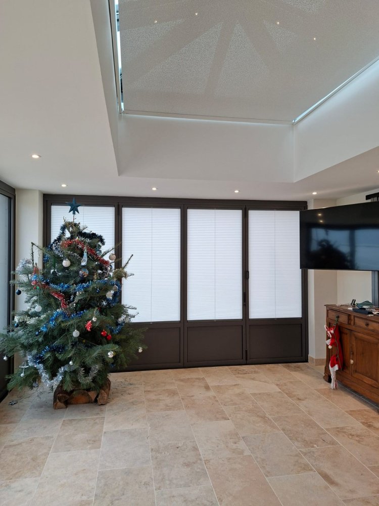 Rénovation et extension d’une habitation d’exception près de Villefranche-sur-Saône (69), intégrant des baies accordéon, une toiture vitrée et des stores sur-mesure.