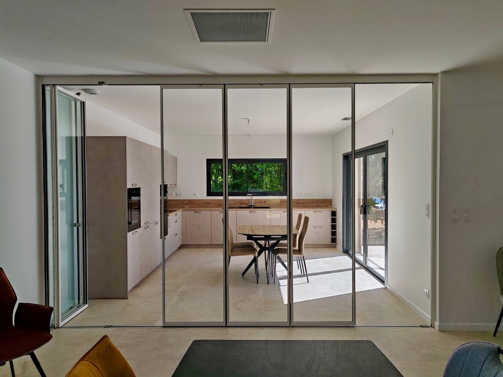 Installation d'un système coulissant-pivotant tout verre effet verrière dans une villa contemporaine basée dans le Rhône (69)