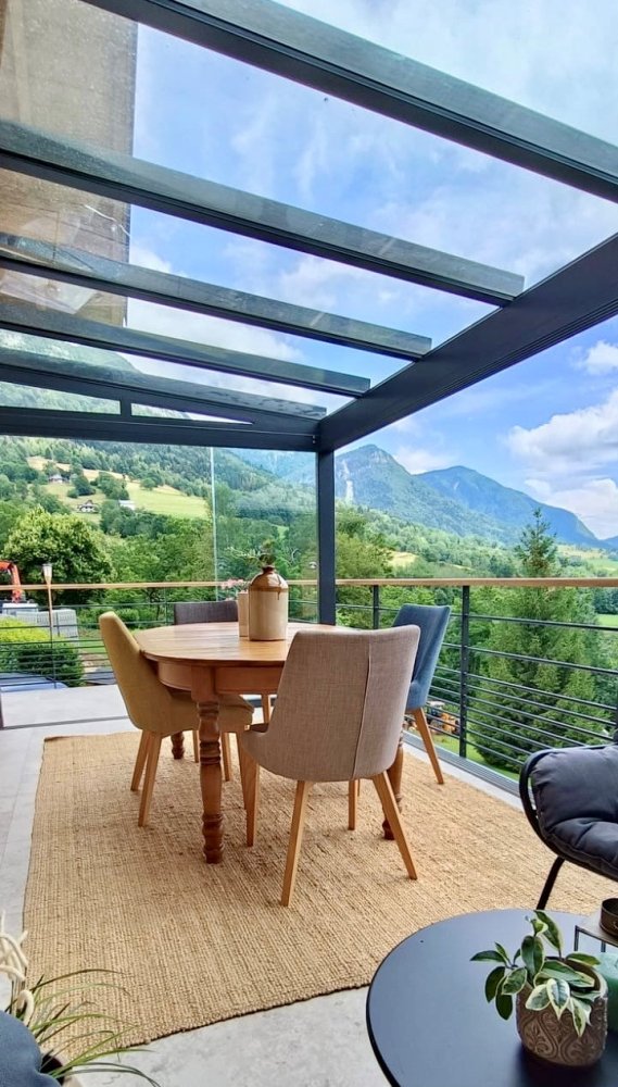 Pose d'une pergola vitrée équipée de coulissants pour profiter d'une vue époustouflante sur la région Haute-Savoie. 