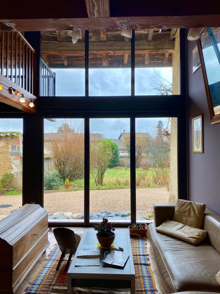 Mise en  place de baies accordéon et d'un châssis fixe dans une charmante maison située dans l'Ain