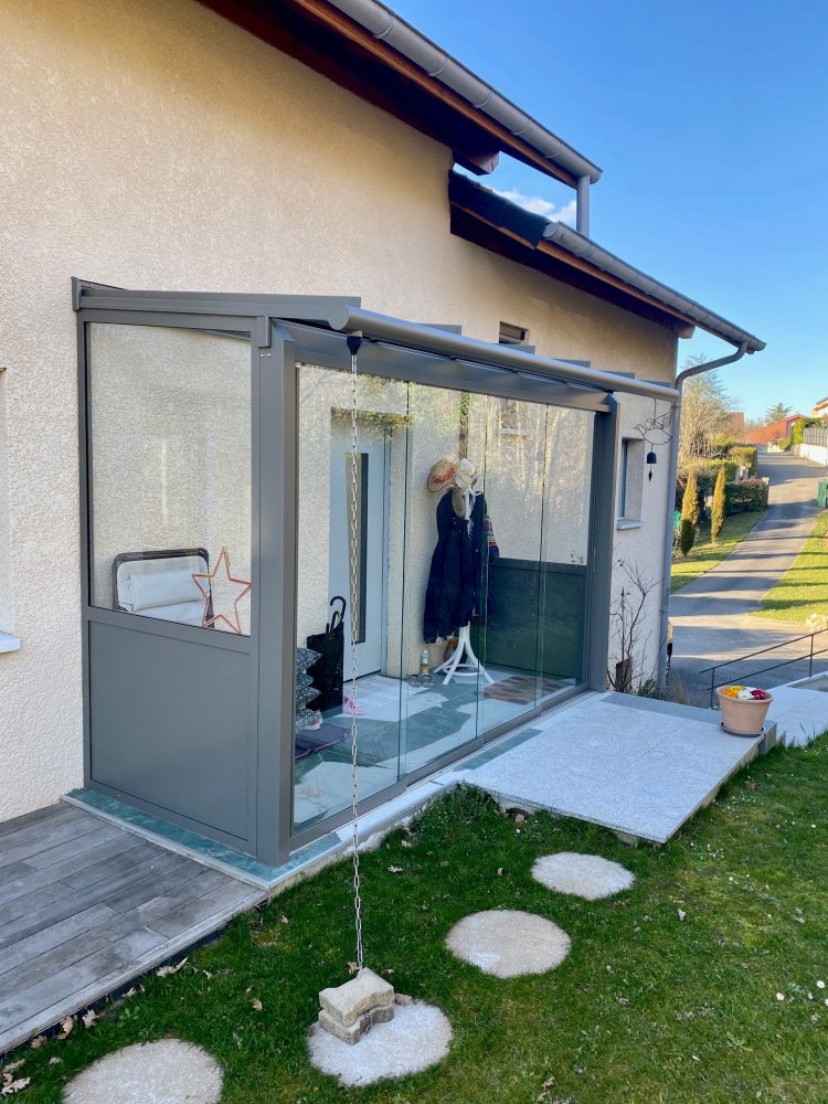 Pose d'une toiture vitrée pour créer un SAS d'entrée entièrement vitrée dans une charmante villa en région Rhône-Alpes.