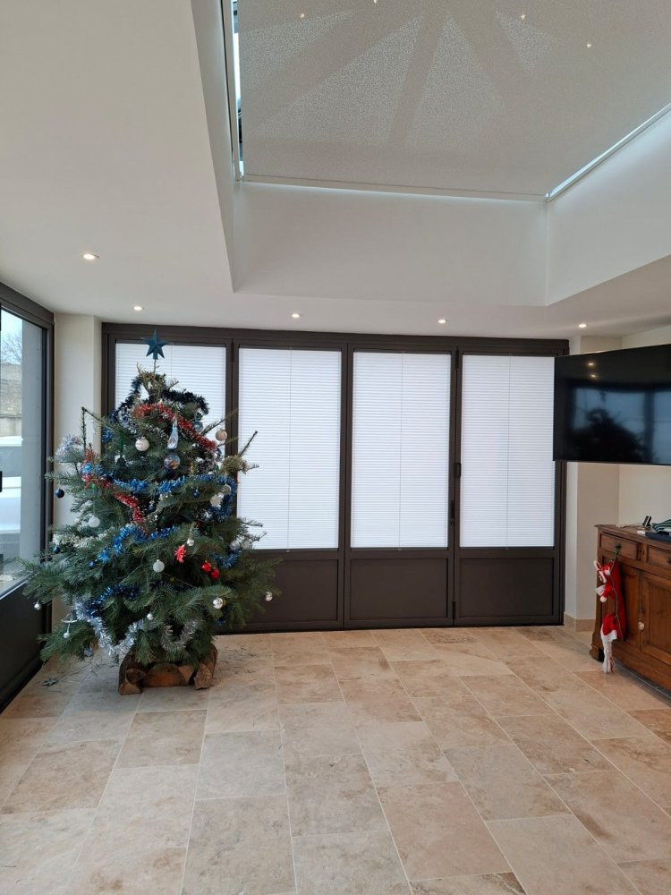 Rénovation et extension d’une habitation d’exception près de Villefranche-sur-Saône (69), intégrant des baies accordéon, une toiture vitrée et des stores sur-mesure.