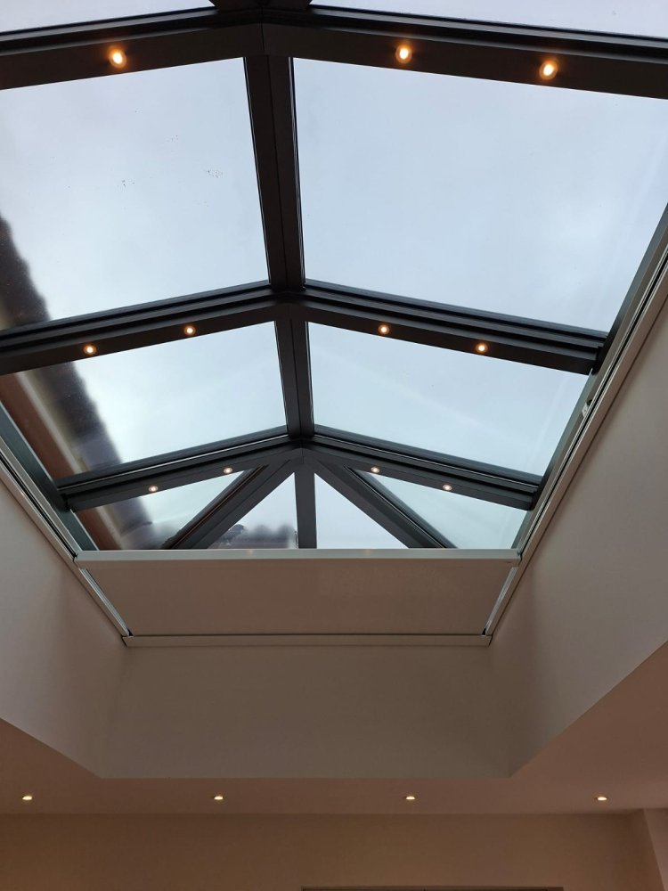 Rénovation et extension d’une habitation d’exception près de Villefranche-sur-Saône (69), intégrant des baies accordéon, une toiture vitrée et des stores sur-mesure.