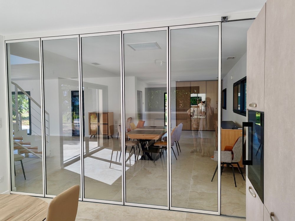Installation d'un système coulissant-pivotant tout verre effet verrière dans une villa contemporaine basée dans le Rhône (69)