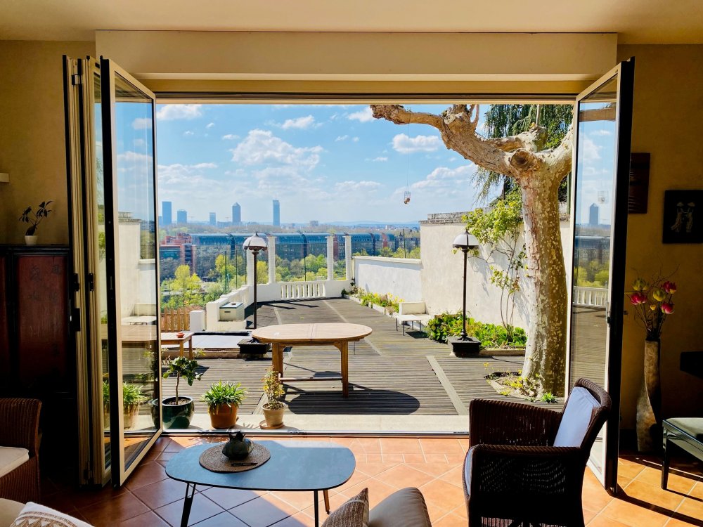 Remplacement d’une baie accordéon en bois par un modèle en aluminium dans une villa surplombant Lyon. 