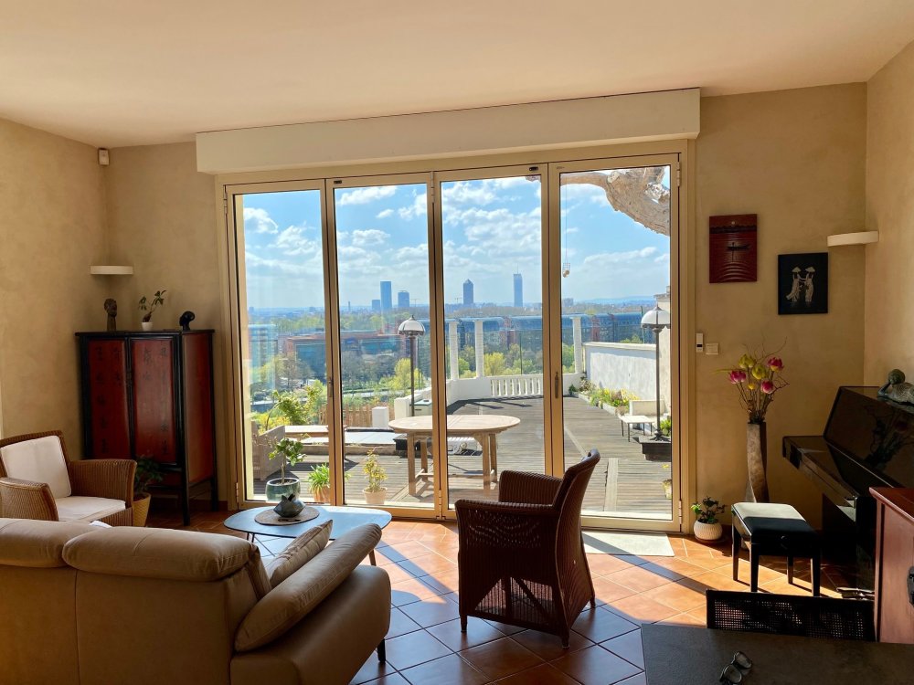 Remplacement d’une baie accordéon en bois par un modèle en aluminium dans une villa surplombant Lyon. 
