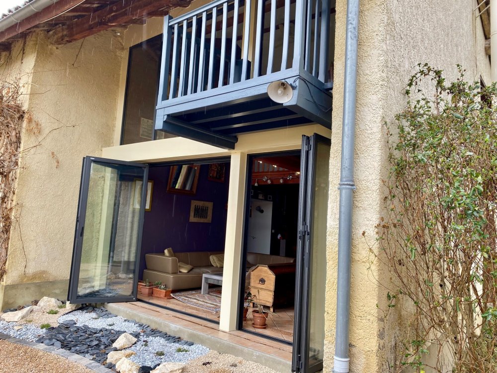Mise en place de baies accordéon et d'un châssis fixe dans une charmante maison située dans l'Ain